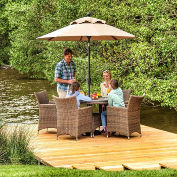Family having breakfast on the private jetty at the Lawson Lodge with the table and chairs and umbrella up on a sunny day.